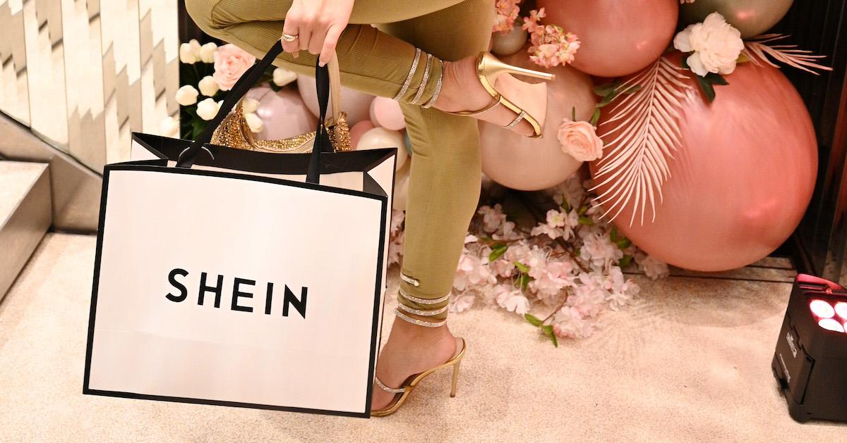A person holds a pink Shein shopping bag.